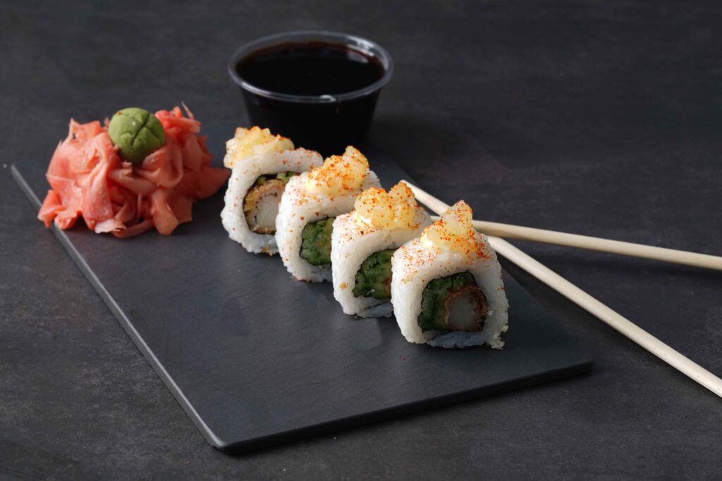 tropical delight sushi with sauce on a black background